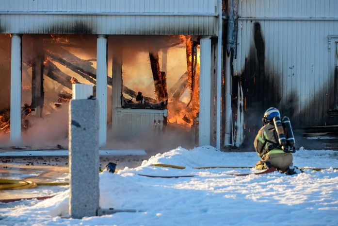 Stor husbrann og brannkonstabel i front.