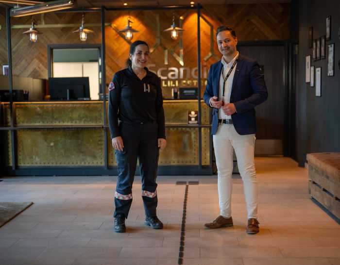 Kvinne i uniform og en mann i en hotellobby