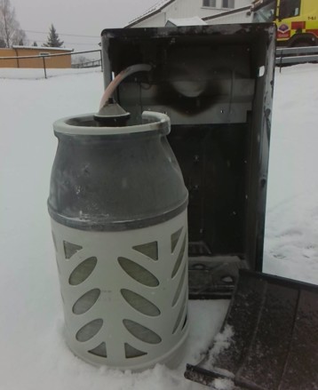 Brent gassovn utendørs i snø.